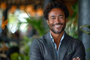 Portrait of a smiling black businessman in a suit with green foliage in the background. photo