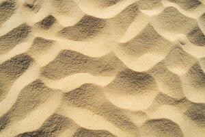 A close-up view of fine sand texture with subtle patterns and varying shades of beige and tan photo