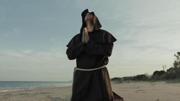 Monk Kneels On The Beach And Starts Praying photo