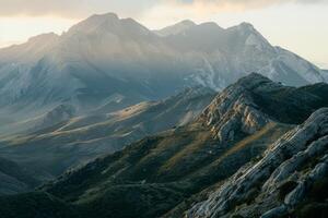 The mountains are covered in snow and the sun is shining on them photo