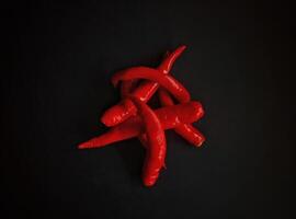 Front view of red chili pepper on a black background photo