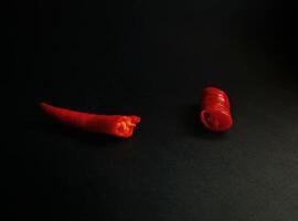 Two red peppers on a black surface photo
