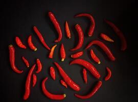 A group of red chili peppers on a black background photo