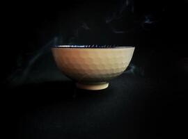 A bowl of tea on a black background photo