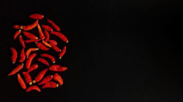 A group of red peppers on a black background with negative space photo