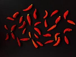 A group of red chili peppers on a black background photo