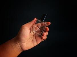 A hand holding a small perfume bottle photo