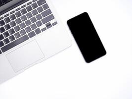 Top view of a laptop and a smartphone isolated on white background. Space for text. Technology and communication concept photo