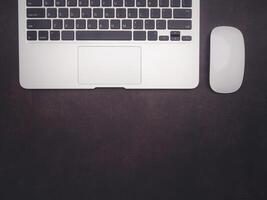 Top view of a laptop and mouse on vintage background with copy space for text. Computer and technology concept photo