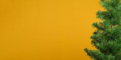 Part of Christmas tree over a yellow background with copy space for text photo