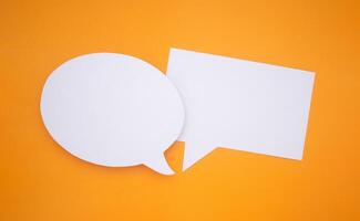 Speech bubble concept. Two empty speech balloons isolated on yellow background with copy space for text. Close-up photo