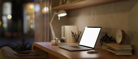 A minimal Scandinavian beige home office workspace at night with a laptop on a wooden table. photo