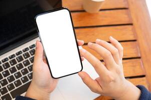 Top view image of a woman using her smartphone while working remotely at a cafe. photo