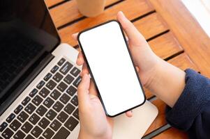 Top view image of a woman using her smartphone while working remotely at a cafe. photo