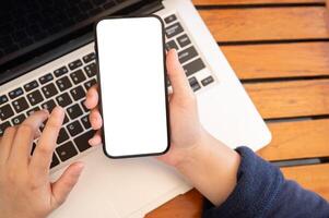 Top view image of a woman using her smartphone while working remotely at a cafe. photo
