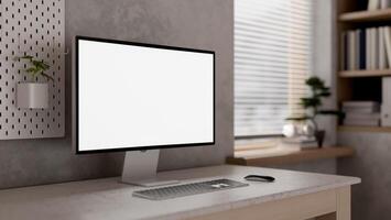 A computer mockup on a table against the cement wall in a modern loft home office. photo