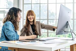 Collaboration of graphic design business people with computer in an office company. Two corporate women in creative marketing team working on project management, Designer teamwork, web design photo