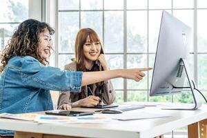 Collaboration of graphic design business people with computer in an office company. Two corporate women in creative marketing team working on project management, Designer teamwork, web design photo