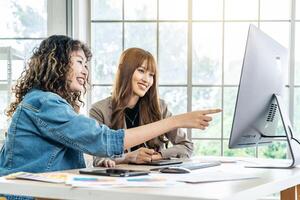 Collaboration of graphic design business people with computer in an office company. Two corporate women in creative marketing team working on project management, Designer teamwork, web design photo