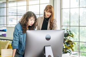 Collaboration of graphic design business people with computer in an office company, Two corporate women in creative marketing team working on project management photo