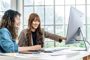 Collaboration of graphic design business people with computer in an office company. Two corporate women in creative marketing team working on project management, Designer teamwork, web design photo