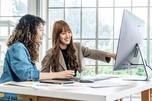 Collaboration of graphic design business people with computer in an office company. Two corporate women in creative marketing team working on project management, Designer teamwork, web design photo