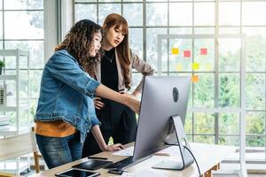 Collaboration of graphic design business people with computer in an office company, Two corporate women in creative marketing team working on project management photo