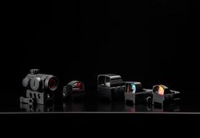 Different modern optical collimator sights on dark back. Sights for rifles, carbines and pistols. photo