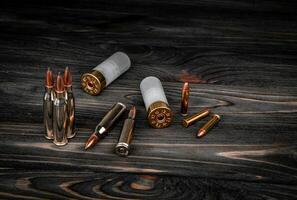Various types of ammunition on a wooden surface. Cartridges for weapons. Dark back. photo