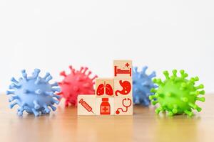 Medical icon on wooden cube block stack on white background and facked colors plastic virus shape, vaccination, laboratory, virus prevention, health, medical technology and insurance concept photo