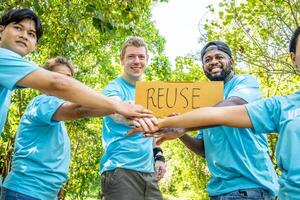 Group of volunteers stand to put your hands up and raise your hands together for help to save nature collecting garbage, Natural environment, pollution concept, Cleaning of nature from waste photo