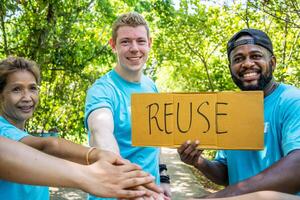 Group of volunteers stand to put your hands up and raise your hands together for help to save nature collecting garbage, Natural environment, pollution concept, Cleaning of nature from waste photo
