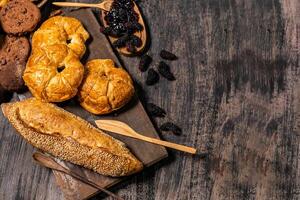 Top view of bread and loaf with cereals bread and bakery, breadsticks on wooden table in dark background with copy space photo