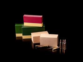 Cartridges for a rifle on a dark back. Different boxes with ammunition for weapons. Bullets for carbines and rifles. photo