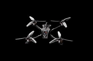 Modern FPV drone on a black background. Four-engine aircraft on the radio control. Drone for racing, filming and entertainment. photo