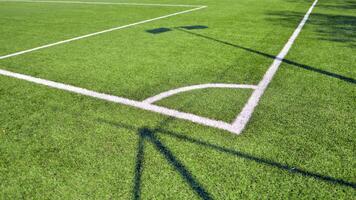 Artificial football turf with a white dividing line. Texture of Perfect green lawn on the football field. photo