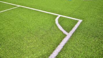 Artificial football turf with a white dividing line. Texture of Perfect green lawn on the football field. photo