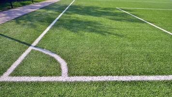 Artificial football turf with a white dividing line. Texture of Perfect green lawn on the football field. photo