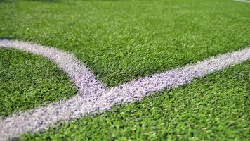 Artificial football turf with a white dividing line. Texture of Perfect green lawn on the football field. photo