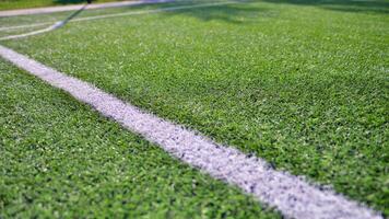Artificial football turf with a white dividing line. Texture of Perfect green lawn on the football field. photo