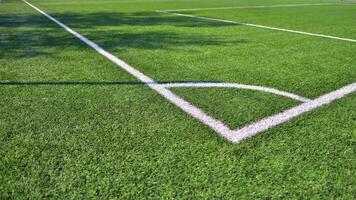 Artificial football turf with a white dividing line. Texture of Perfect green lawn on the football field. photo
