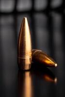 Bullet isolated on black background with reflexion. Rifle bullets close-up on black photo