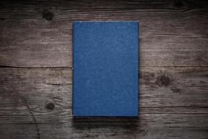 Closed book on vintage wooden background. Old book on the wooden table. Closed book with empty cover laying on wooden table. photo