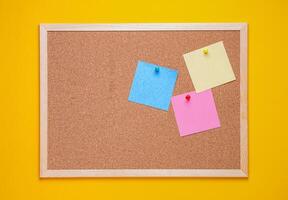 multicolored corkboard stickers pinned with buttons. yellow background. photo