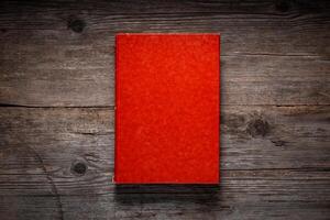 Closed book on vintage wooden background. Old book on the wooden table. Closed book with empty cover laying on wooden table. photo