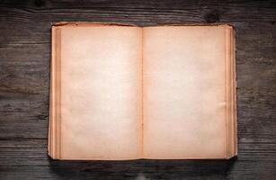 Vintage book, open, on old wooden table, with clipping path. Open Book blank on old wooden background. book with blank pages photo