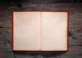 Vintage book, open, on old wooden table, with clipping path. Open Book blank on old wooden background. book with blank pages photo
