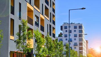 New modern block of flats in green area. Eco apartment building saving energy and fresh air concept. Green tree and new apartment building. The harmony of nature and modernity. photo