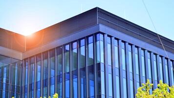 City life, urban landscape and ecology. Modern office complex with glass facades and smooth lines against backdrop of green trees, concept of modern architecture. Organically building into nature. photo