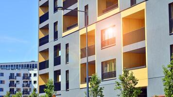 New modern block of flats in green area. Eco apartment building saving energy and fresh air concept. Green tree and new apartment building. The harmony of nature and modernity. photo